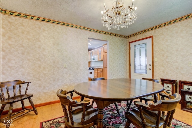 132 S First St, Jamestown, IN 46147 - dining space featuring light wood-style floors, a textured ceiling, a chandelier, and wallpapered walls