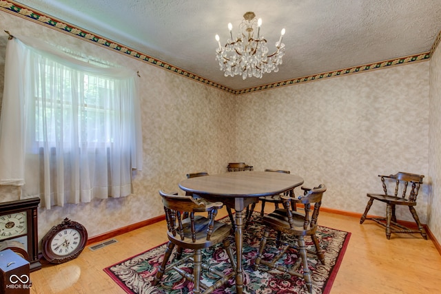 132 S First St, Jamestown, IN 46147 - dining space featuring light wood-style floors, a chandelier, a textured ceiling, wallpapered walls, and baseboards