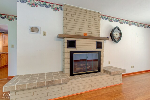 132 S First St, Jamestown, IN 46147 - detailed view of a brick fireplace, wood finished floors, and baseboards