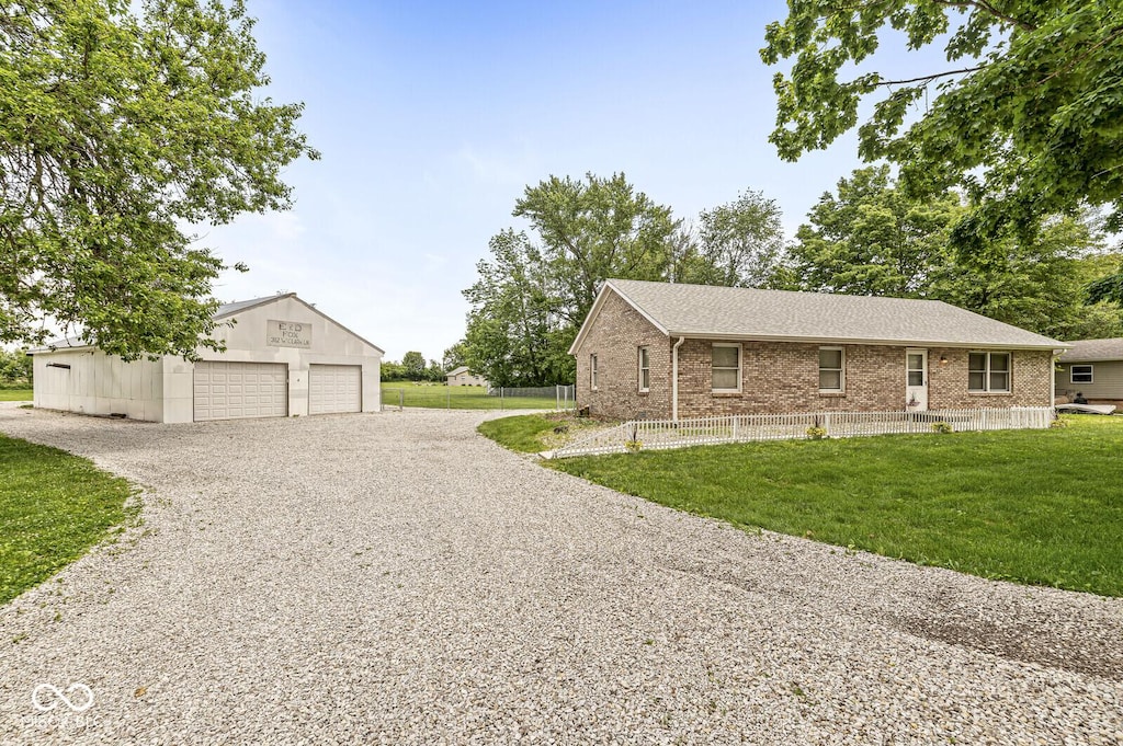 312 W Clark Ln, Fairland, IN 46126 - view of front facade featuring a garage, an outdoor structure, brick siding, and a shingled roof