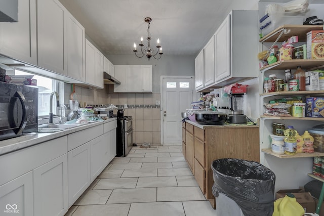 952 Lasalle St, Indianapolis, IN 46201 - kitchen featuring under cabinet range hood, double oven range, a chandelier, and white cabinetry