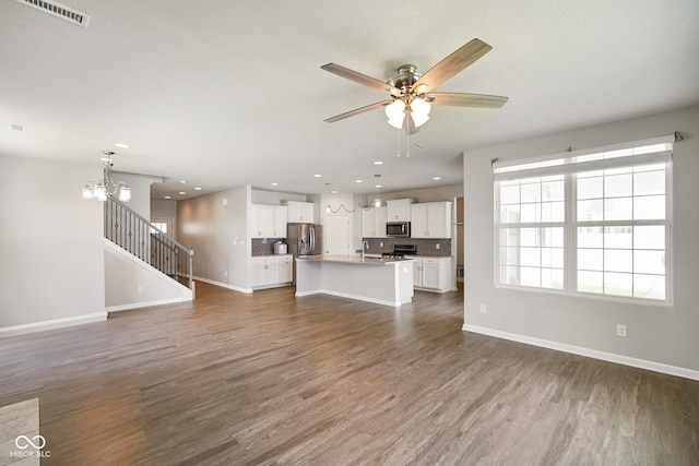 6830 Park Grove Blvd, Whitestown, IN 46075 - unfurnished living room with dark wood-style flooring, ceiling fan, baseboards, recessed lighting, and a chandelier