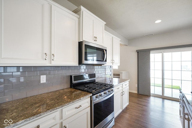 6830 Park Grove Blvd, Whitestown, IN 46075 - kitchen with appliances with stainless steel finishes, backsplash, dark wood-style floors, white cabinets, and recessed lighting