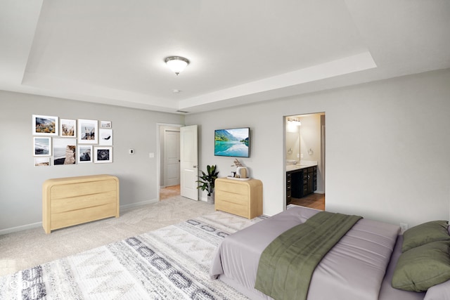 6830 Park Grove Blvd, Whitestown, IN 46075 - bedroom featuring a raised ceiling, baseboards, light colored carpet, and ensuite bath