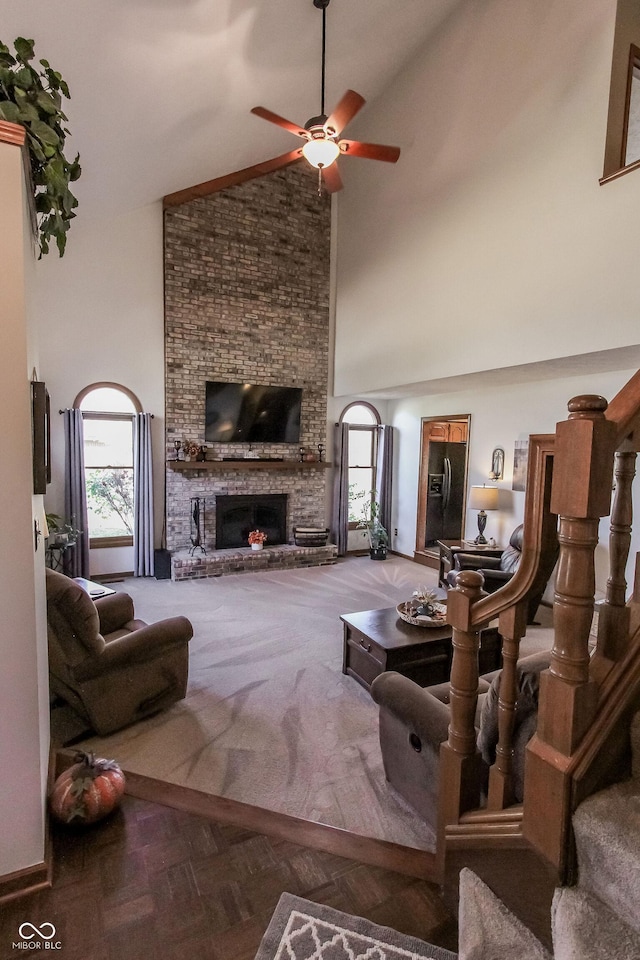 3819 S Village Dr, New Palestine, IN 46163 - carpeted living room with high vaulted ceiling, plenty of natural light, ceiling fan, a fireplace, and stairs
