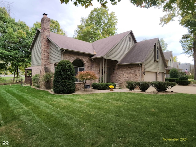 3819 S Village Dr, New Palestine, IN 46163 - view of front of house featuring a chimney, brick siding, a front lawn, and a garage