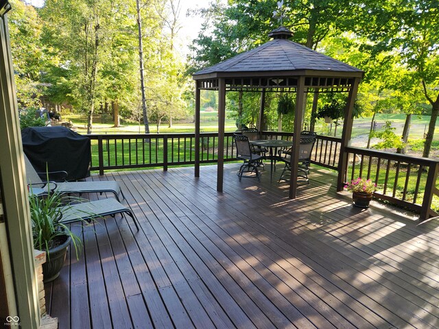 3819 S Village Dr, New Palestine, IN 46163 - wooden terrace featuring outdoor dining area, grilling area, a gazebo, a lawn, and view of scattered trees