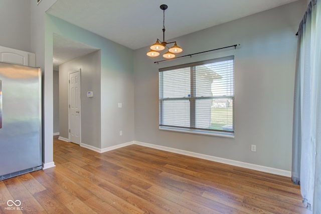 2234 Burgundy Way, Plainfield, IN 46168 - spare room featuring wood finished floors, baseboards, and a chandelier