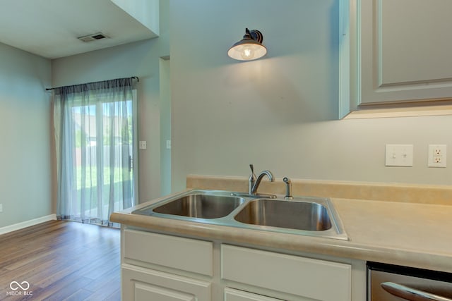 2234 Burgundy Way, Plainfield, IN 46168 - kitchen featuring a sink, stainless steel dishwasher, wood finished floors, light countertops, and white cabinetry