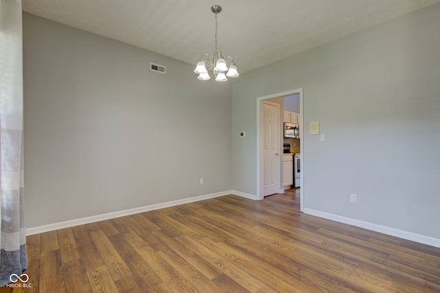 2234 Burgundy Way, Plainfield, IN 46168 - spare room featuring a chandelier, wood finished floors, and baseboards