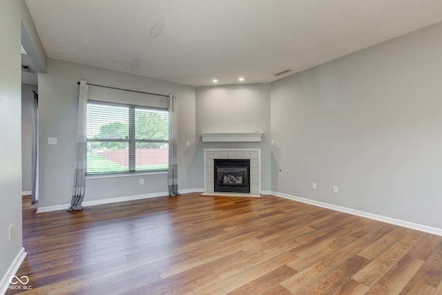 2234 Burgundy Way, Plainfield, IN 46168 - unfurnished living room featuring wood finished floors, a tiled fireplace, baseboards, and recessed lighting