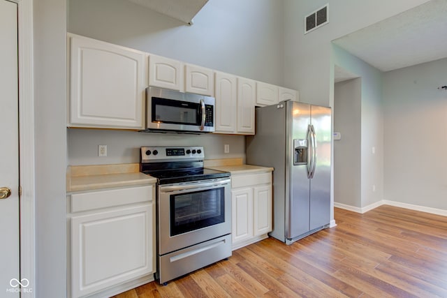 2234 Burgundy Way, Plainfield, IN 46168 - kitchen with stainless steel appliances, white cabinets, light wood-style flooring, and light countertops