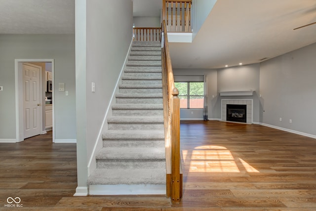 2234 Burgundy Way, Plainfield, IN 46168 - staircase featuring wood finished floors, baseboards, and a tiled fireplace