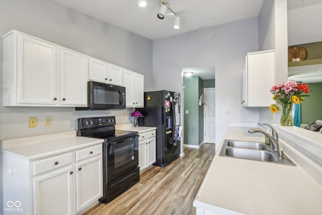 2114 Turning Leaf Dr, Franklin, IN 46131 - kitchen featuring black appliances, a sink, white cabinets, light wood-style flooring, and light countertops