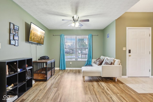 2114 Turning Leaf Dr, Franklin, IN 46131 - living area featuring wood finished floors, a ceiling fan, a textured ceiling, and baseboards