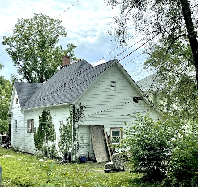 1139 S 7th St, Terre Haute, IN 47802 - rear view of house featuring roof with shingles, a chimney, and a yard