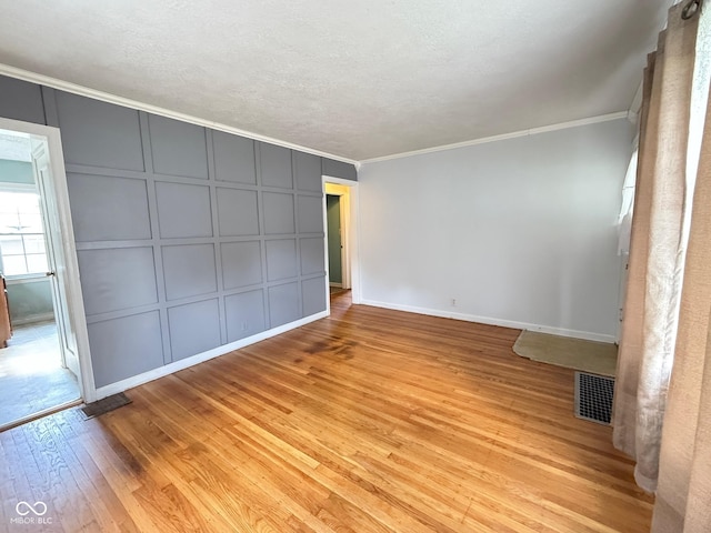 4853 Wentworth Blvd, Indianapolis, IN 46201 - unfurnished room featuring a decorative wall, crown molding, and light wood-style floors