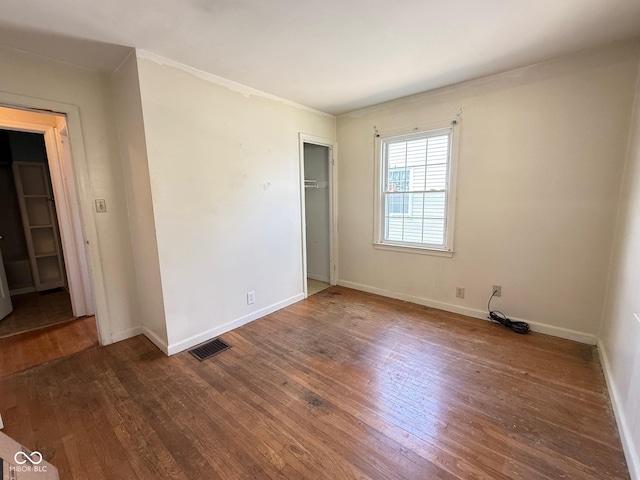 4853 Wentworth Blvd, Indianapolis, IN 46201 - unfurnished bedroom with dark wood-type flooring, a closet, and crown molding
