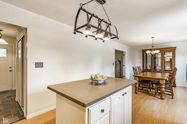 7935 N County Road 650 E, Brownsburg, IN 46112 - kitchen with dark countertops, a chandelier, a center island, white cabinetry, and ornamental molding