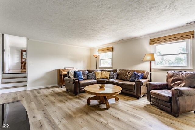 7935 N County Road 650 E, Brownsburg, IN 46112 - living room featuring light wood-style flooring, crown molding, a textured ceiling, and stairs