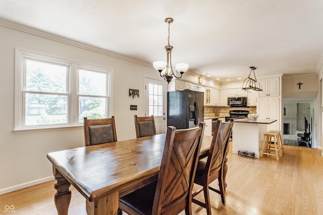 7935 N County Road 650 E, Brownsburg, IN 46112 - dining space with light wood-style floors, a chandelier, and crown molding