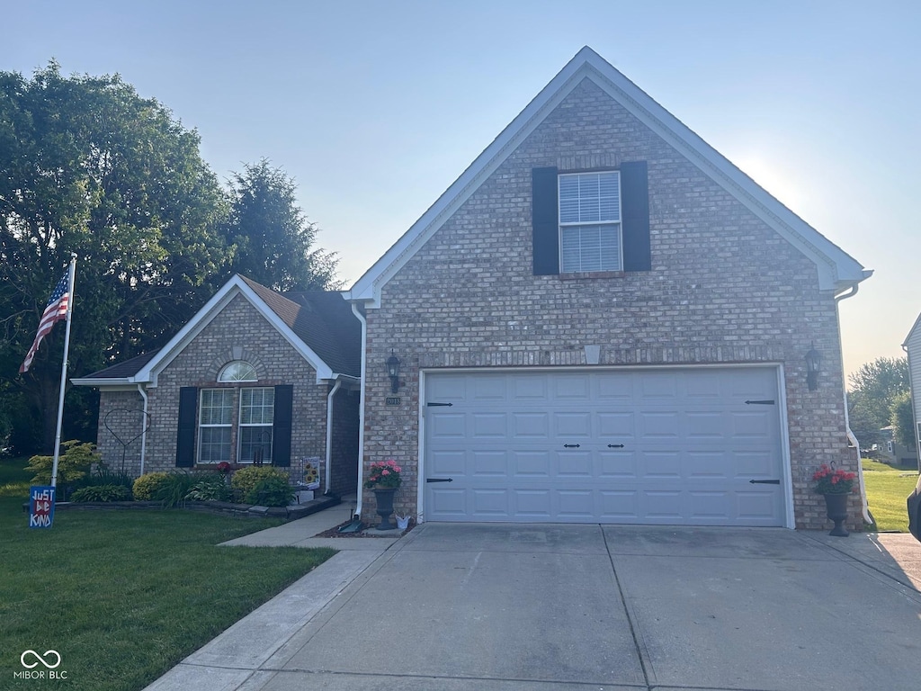 2018 Alysheba Dr, Indianapolis, IN 46234 - traditional home featuring a front yard, concrete driveway, brick siding, and an attached garage