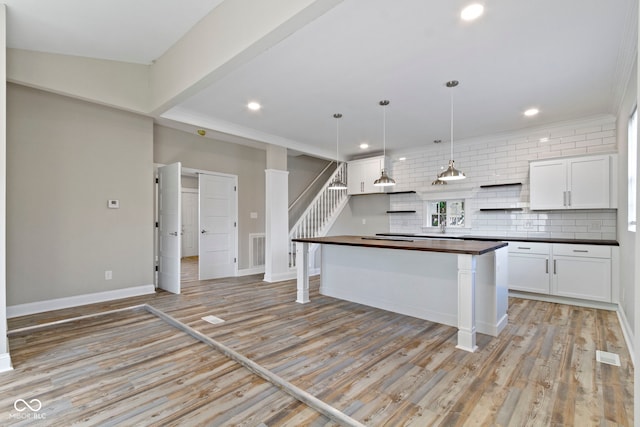 2111 S A St, Elwood, IN 46036 - kitchen featuring backsplash, white cabinetry, light wood-type flooring, recessed lighting, and decorative light fixtures