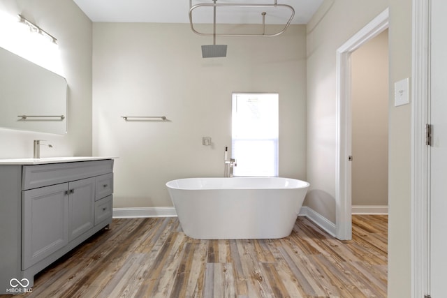 2111 S A St, Elwood, IN 46036 - bathroom with vanity, a freestanding tub, wood finished floors, and baseboards