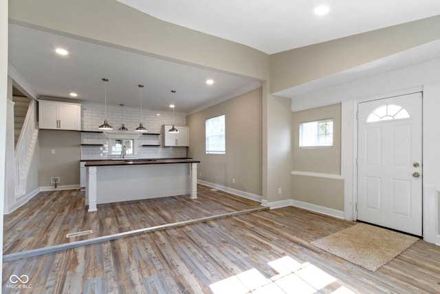 2111 S A St, Elwood, IN 46036 - kitchen with dark countertops, tasteful backsplash, white cabinetry, light wood-style flooring, and baseboards