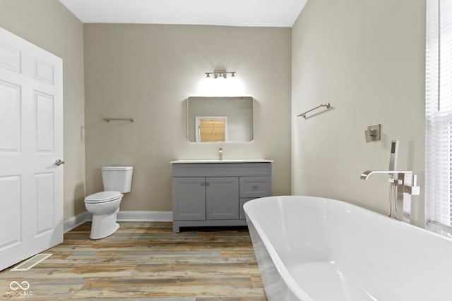2111 S A St, Elwood, IN 46036 - bathroom with a freestanding bath, vanity, wood finished floors, toilet, and baseboards