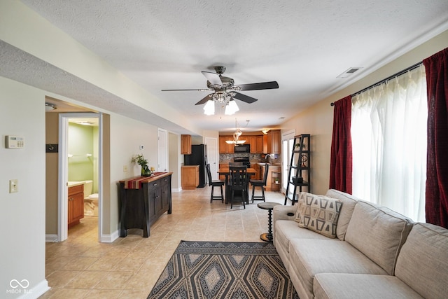 101 Meadowview Dr, Mooresville, IN 46158 - living room with light tile patterned floors, a ceiling fan, baseboards, a textured ceiling, and a chandelier