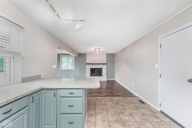 8205 Picadilly Ln, Indianapolis, IN 46256 - kitchen with a fireplace, tasteful backsplash, a peninsula, open floor plan, and rail lighting