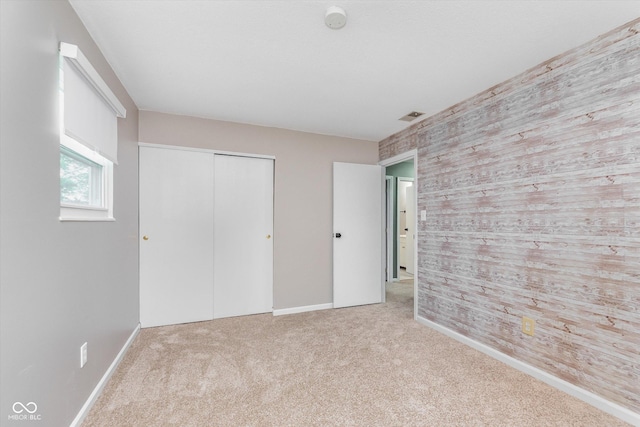 8205 Picadilly Ln, Indianapolis, IN 46256 - unfurnished bedroom featuring an accent wall, carpet flooring, baseboards, a closet, and wooden walls