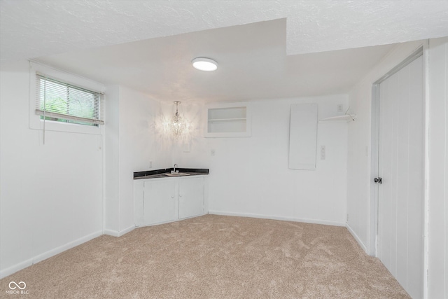 8205 Picadilly Ln, Indianapolis, IN 46256 - below grade area featuring light colored carpet, a textured ceiling, baseboards, a chandelier, and a sink