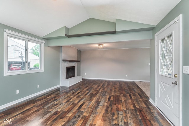 8205 Picadilly Ln, Indianapolis, IN 46256 - unfurnished living room with vaulted ceiling, wood finished floors, a brick fireplace, and baseboards