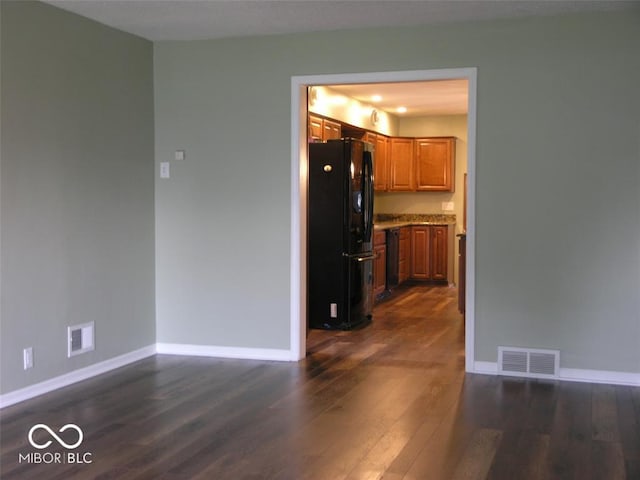 3456 S Sadlier Dr S, Indianapolis, IN 46239 - kitchen featuring freestanding refrigerator, brown cabinetry, dark wood-type flooring, and baseboards