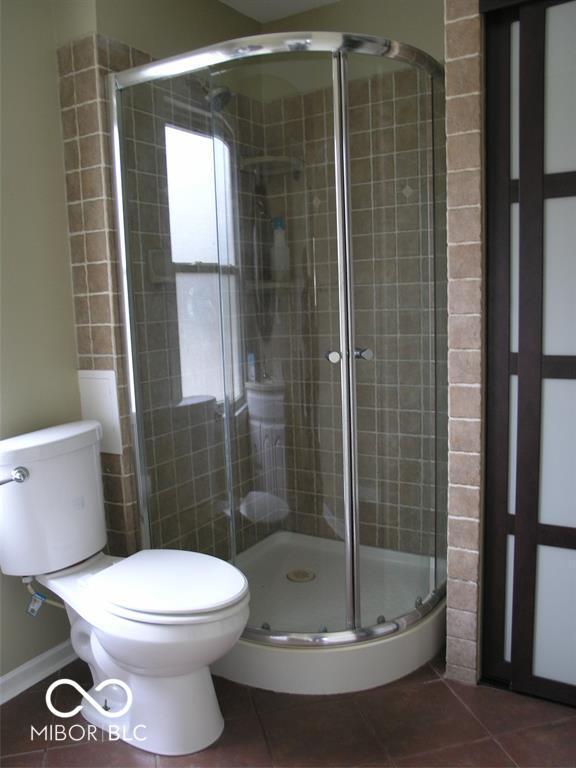 3456 S Sadlier Dr S, Indianapolis, IN 46239 - full bathroom with toilet, tile patterned floors, and a stall shower