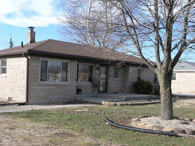 3456 S Sadlier Dr S, Indianapolis, IN 46239 - view of front facade featuring a chimney, stone siding, a shingled roof, and a front yard