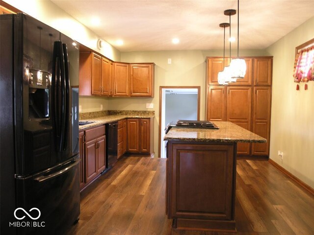 3456 S Sadlier Dr S, Indianapolis, IN 46239 - kitchen with black appliances, a kitchen island, dark wood finished floors, light stone counters, and hanging light fixtures