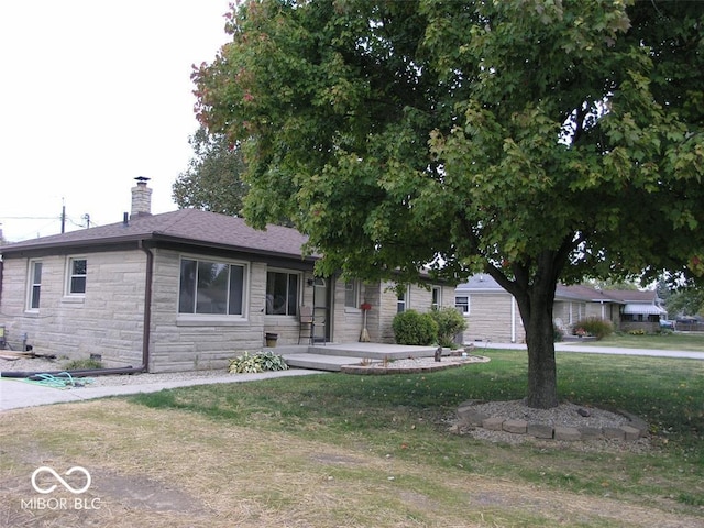 3456 S Sadlier Dr S, Indianapolis, IN 46239 - single story home with stone siding, a chimney, and a front yard