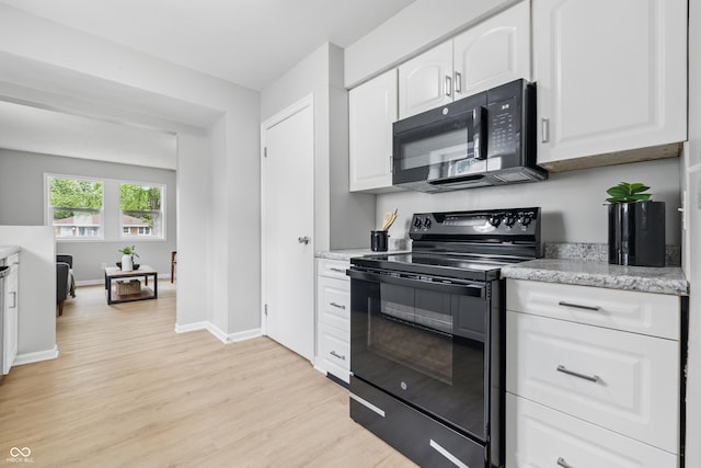 450 N Fenton Ave, Indianapolis, IN 46219 - kitchen with black appliances, light wood-type flooring, white cabinetry, and light stone countertops
