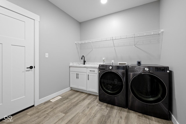 4545 Caroline Grace Ln, Terre Haute, IN 47802 - laundry room with washing machine and dryer, light wood-type flooring, and cabinet space
