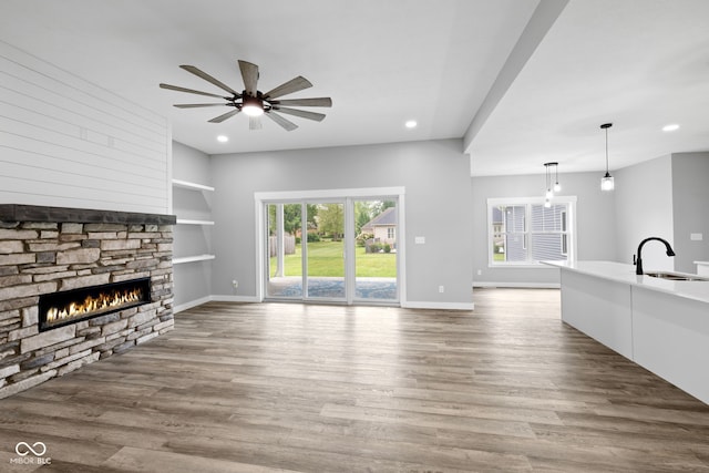 4545 Caroline Grace Ln, Terre Haute, IN 47802 - unfurnished living room with a fireplace, a ceiling fan, wood finished floors, recessed lighting, and built in shelves