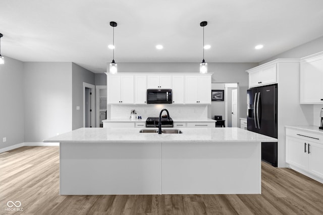 4545 Caroline Grace Ln, Terre Haute, IN 47802 - kitchen featuring black appliances, a center island with sink, white cabinets, backsplash, and light wood-style flooring