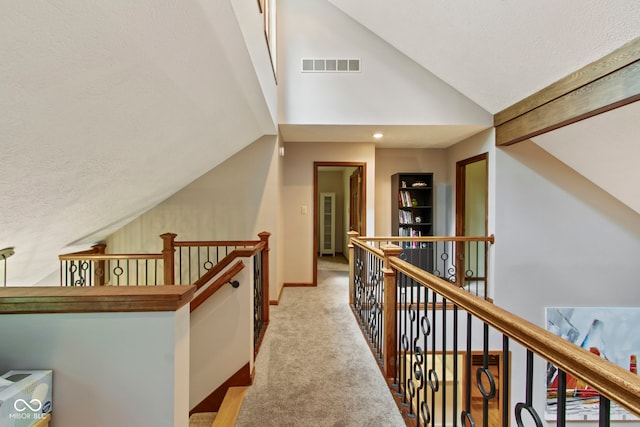 7426 Shadow Wood Dr, Indianapolis, IN 46254 - hall with an upstairs landing, lofted ceiling, a textured ceiling, carpet floors, and baseboards