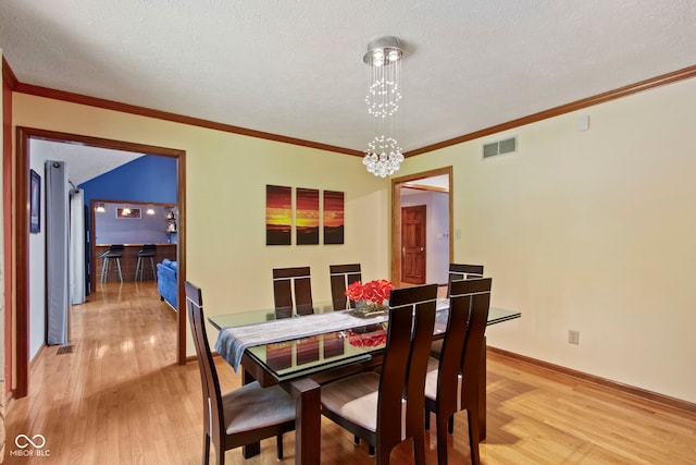 7426 Shadow Wood Dr, Indianapolis, IN 46254 - dining room with light wood-style flooring, a chandelier, crown molding, baseboards, and a textured ceiling
