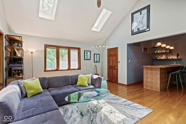 7426 Shadow Wood Dr, Indianapolis, IN 46254 - living room with a skylight, bar, high vaulted ceiling, and light wood-style flooring