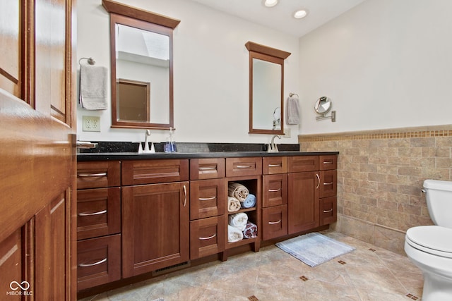 7426 Shadow Wood Dr, Indianapolis, IN 46254 - full bath with tile walls, wainscoting, toilet, and double vanity
