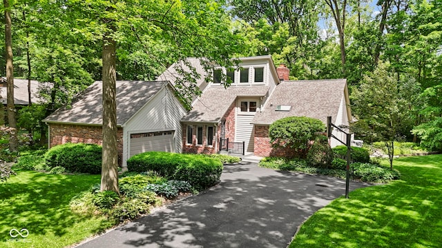 7426 Shadow Wood Dr, Indianapolis, IN 46254 - view of front of home featuring an attached garage, a front lawn, a chimney, and brick siding