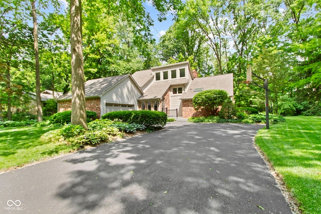 7426 Shadow Wood Dr, Indianapolis, IN 46254 - view of front of home featuring a front lawn, brick siding, and view of wooded area